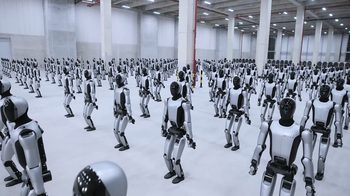 Rob&ocirc;s humanoides Walker S2 ocupam um grande armaz&eacute;m industrial, distribu&iacute;dos em m&uacute;ltiplas fileiras e posi&ccedil;&otilde;es padronizadas.