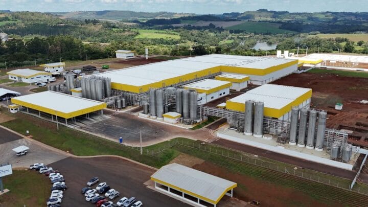 Vista aérea ampla da fábrica com galpões, tanques e vias internas.