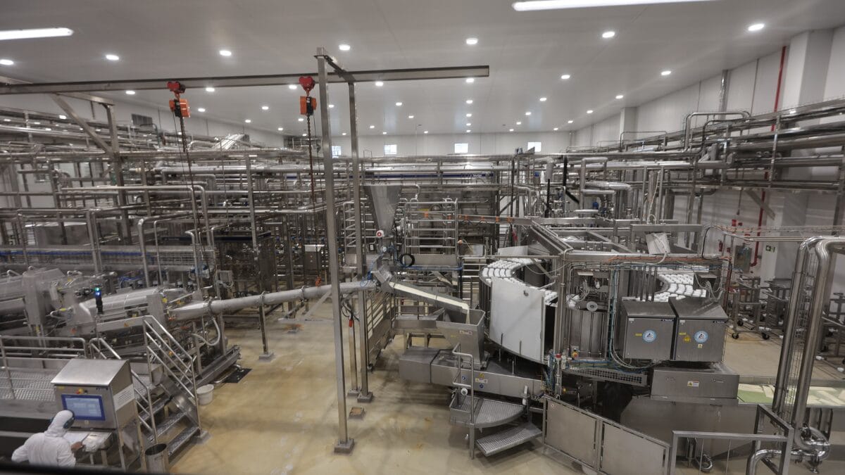 Equipamentos industriais e tubula&ccedil;&otilde;es na &aacute;rea interna da f&aacute;brica de latic&iacute;nios.