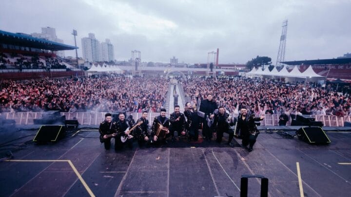 banda Corpo e Alma sobre o palco, tirando foto com grande público num dia nublado