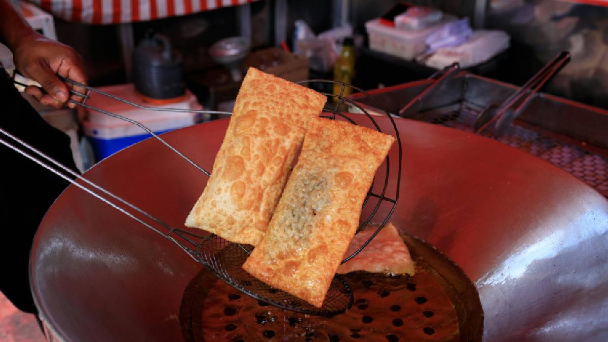 O momento da retirada revela o pastel pronto para ser servido com o recheio bem selado (Imagem: Magnific)