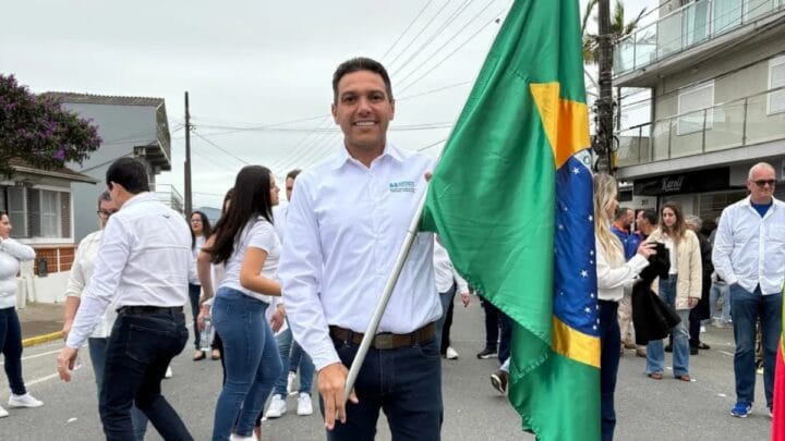 Foto mostra prefeito de Balneário Piçarras, Tiago Baltt, segurando bandeira do Brasil na cidade