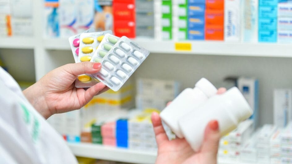pessoa segurando medicamentos em uma farmácia