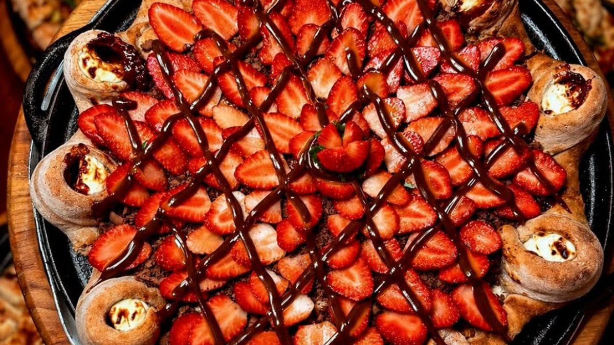 Pizza com recheio farto de morangos, calda de chocolate e borda recheada, da Pizzaria Bel Mangio.