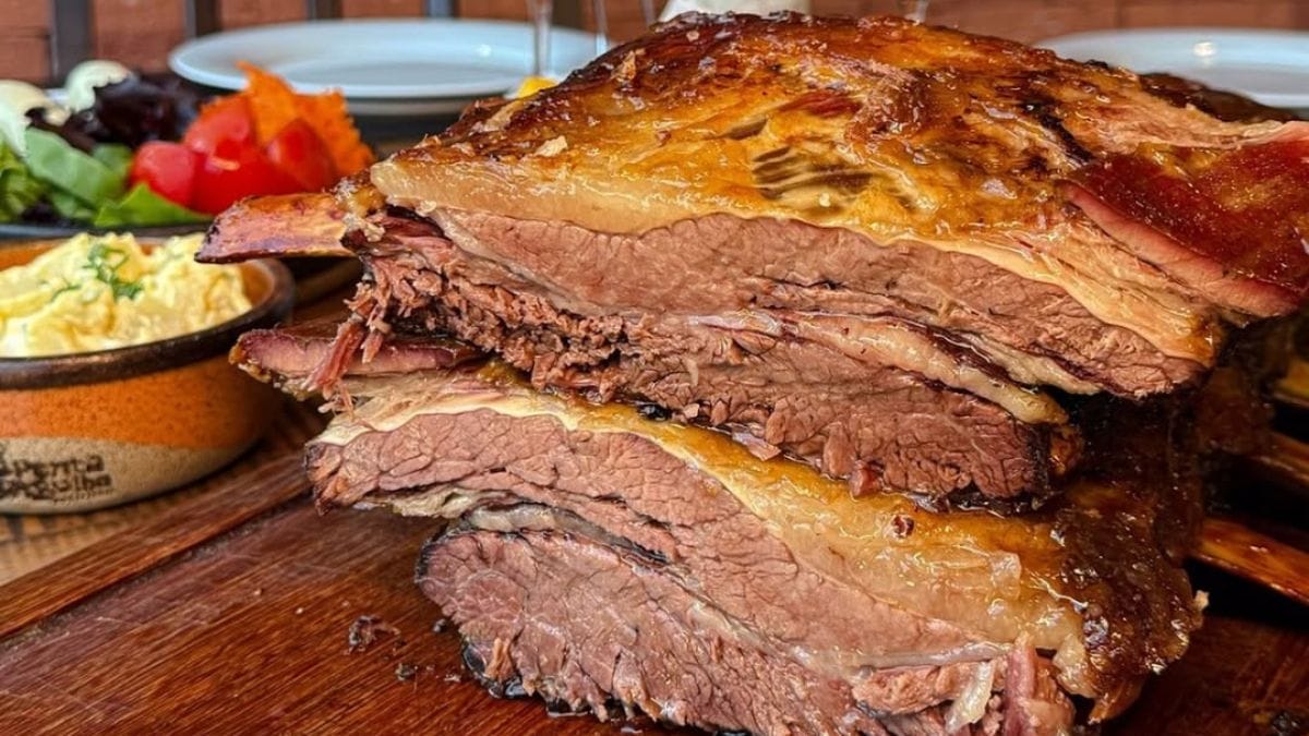 Costela assada e suculenta cortada sobre uma tábua de madeira, da Ponta d’Agulha Costelaria. em Restaurantes em Florianópolis.