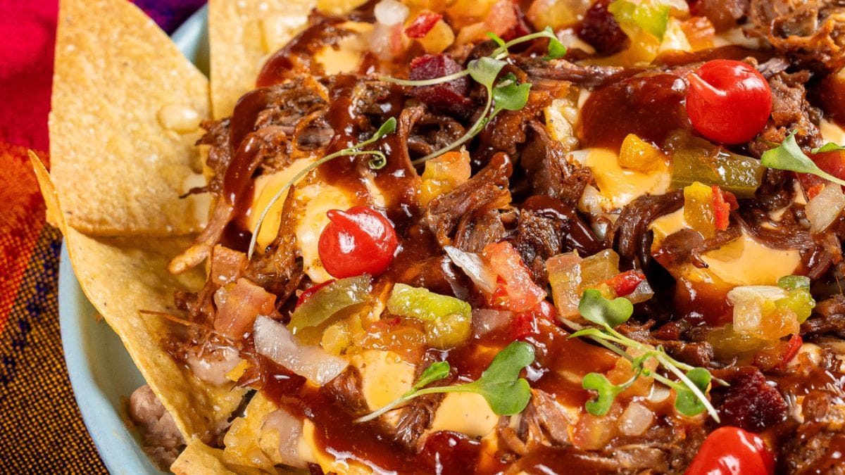Porção de nachos com recheio generoso de carne desfiada, molhos, pimenta, tomate e temperos, do Guacamole Cocina Mexicana, em Restaurantes em Florianópolis.