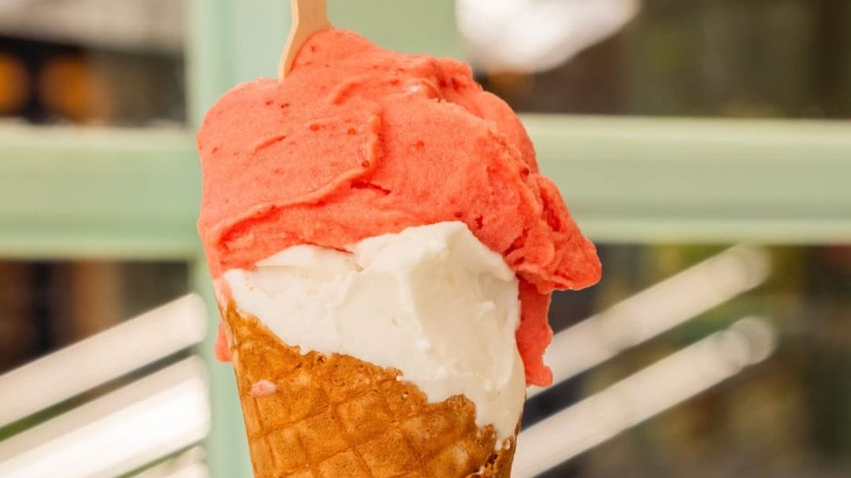 Sorvete de casquinha com duas bolas, nas cores rosa e branco, da Nicoline Gelato.