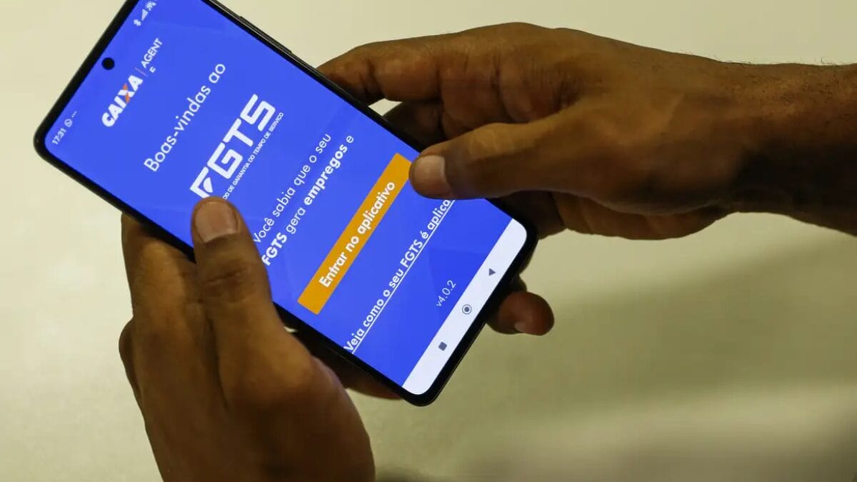 pessoa segurando celular com tela mostrando o aplicativo do FGTS