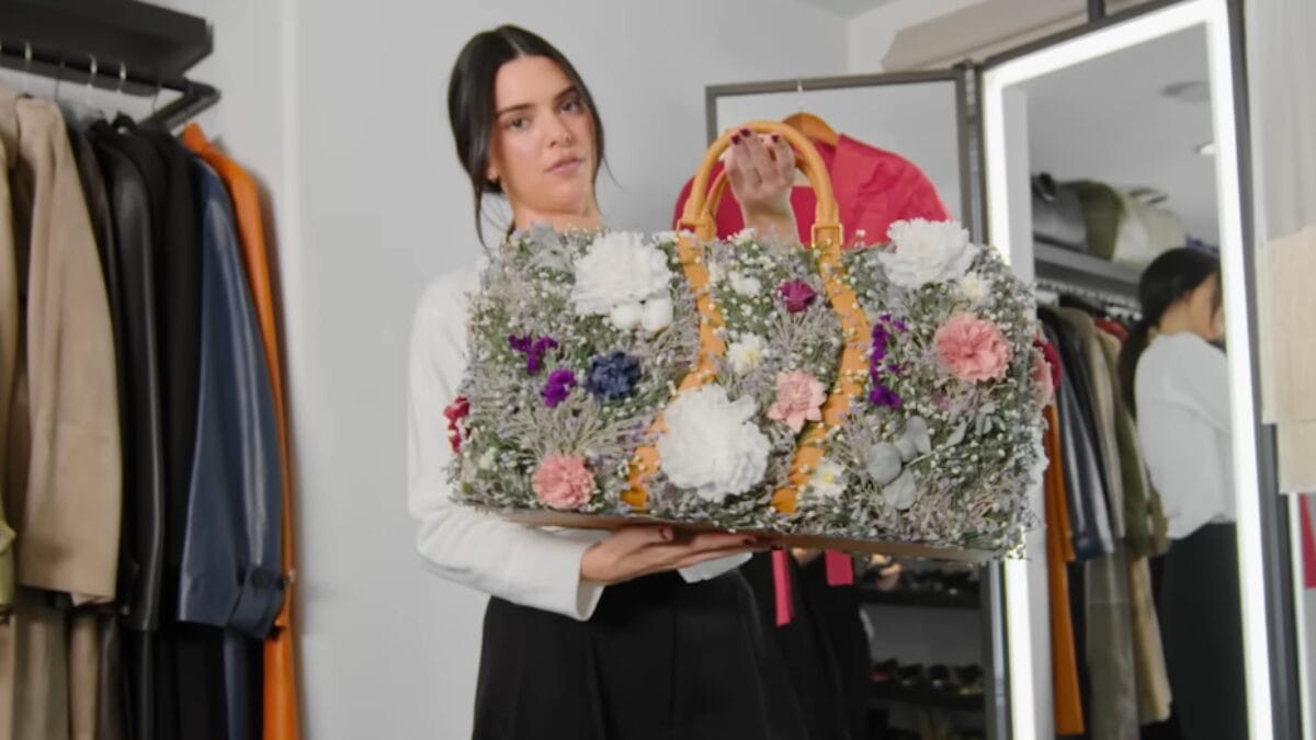 Kendall Jenner segura bolsa decorada com flores dentro do closet.