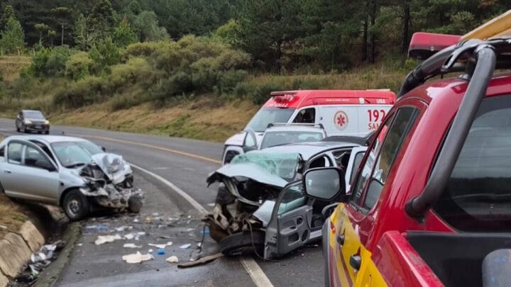 carros de cor prata completamente destruídos por acidentes, ao lado de ambulância