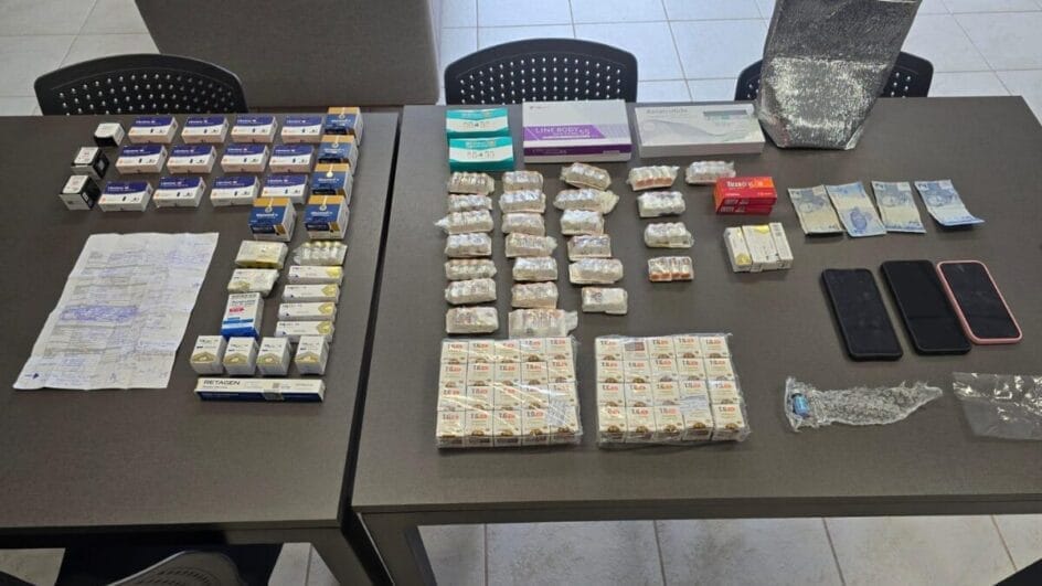 medicamentos, dinheiro e celulares apreendidos e dispostos ordenadamente sobre uma mesa