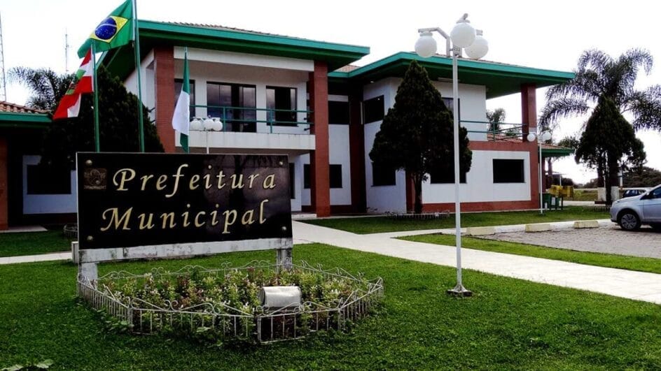 edificação em branco, verde e vermelho, com uma placa escrito Prefeitura Municipal