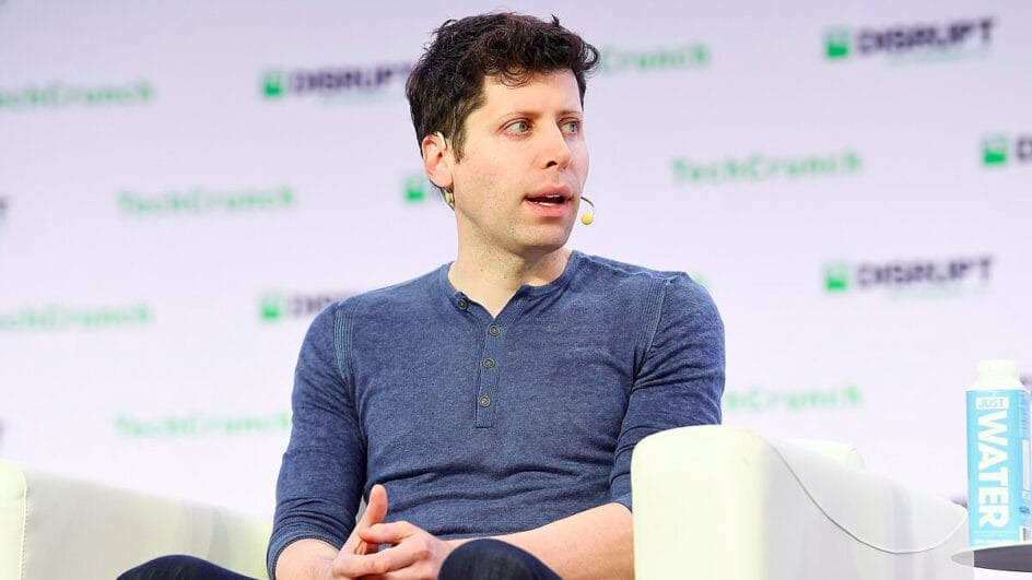 Retrato do empresário Sam Altman vestindo uma camiseta azul durante uma palestra sobre tecnologia.