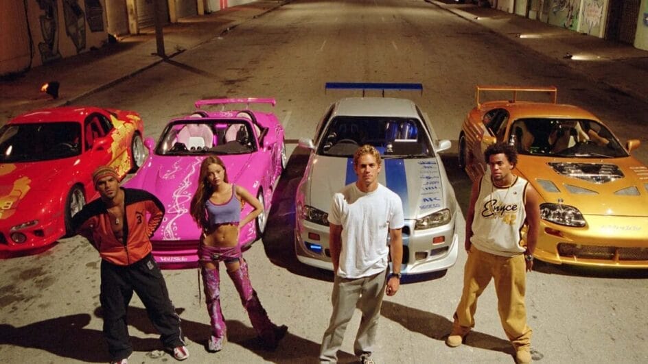 Carros coloridos e personagens em volta da rua mostram a fase em que Velozes e Furiosos ainda tinha forte ligação com a cultura tuner. (Foto: Reprodução/Universal Pictures)
