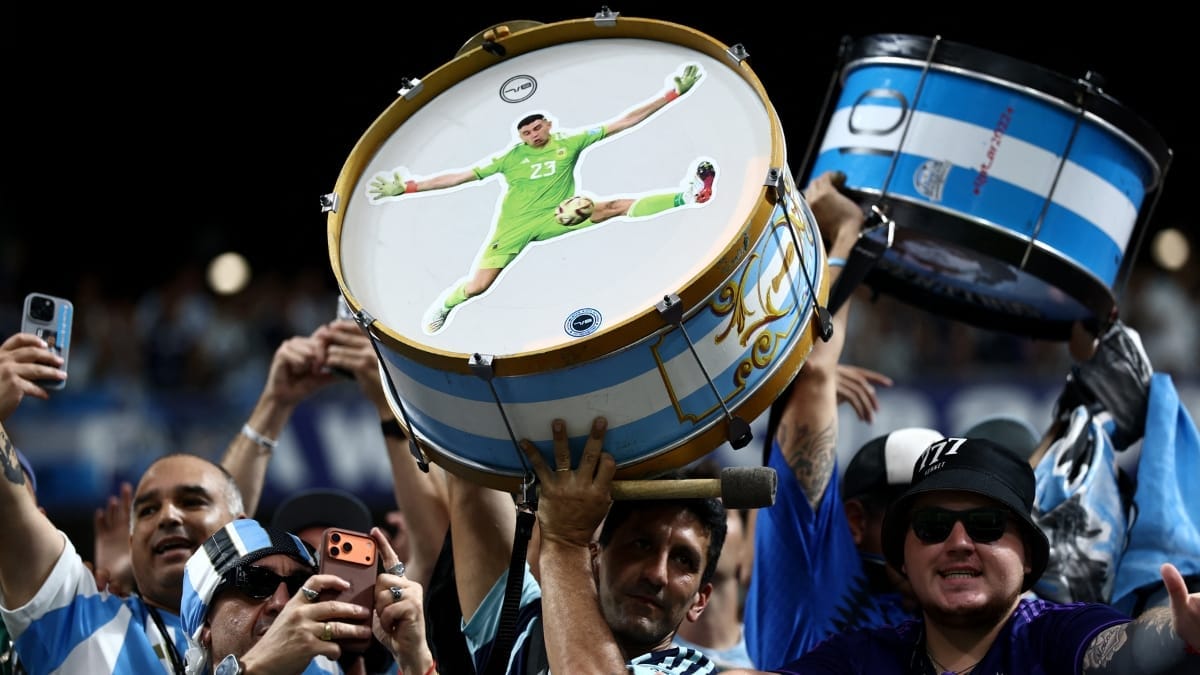 Torcedor argentino exibe um tambor com a imagem de Emiliano Martínez dentro do estádio antes da partida.