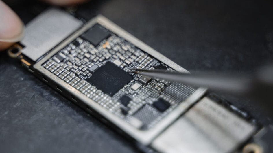 Visão detalhada de um chip processador instalado em uma placa de circuito de um smartphone moderno.
