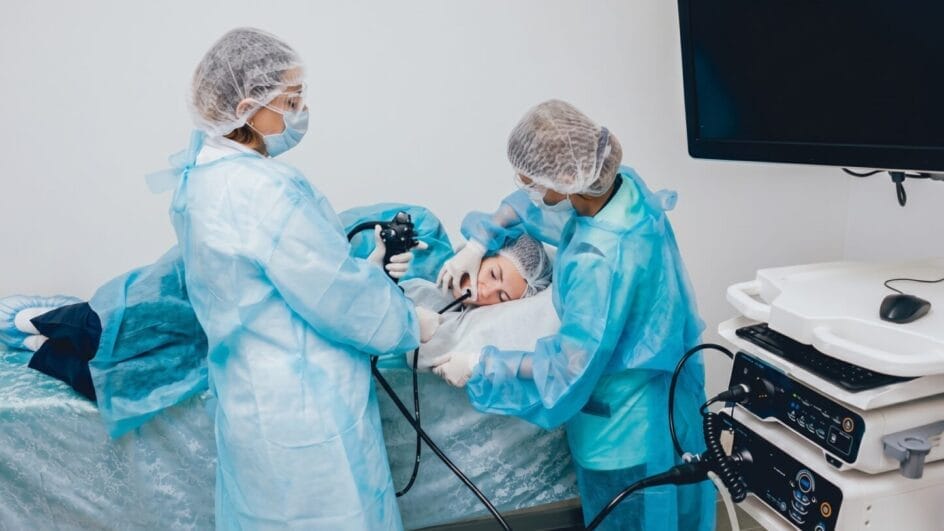 Médicos estão fazendo exame de endoscopia em paciente deitado em maca