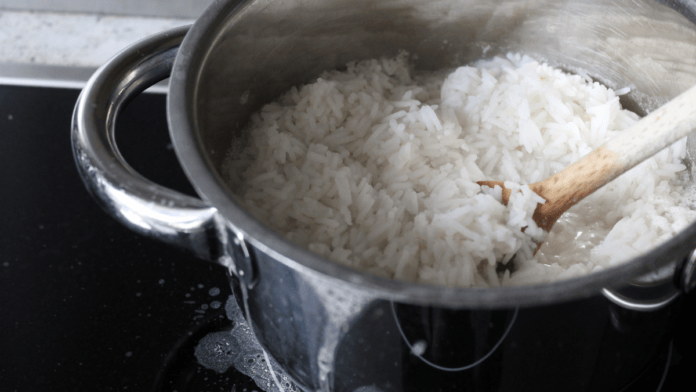 Foto real de panela aberta com arroz branco cozido, vista de cima, luz natural.