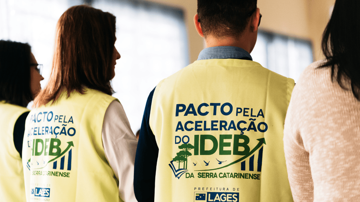 pessoas com coletes amarelos escrito "pacto pela aceleração do Ideb"