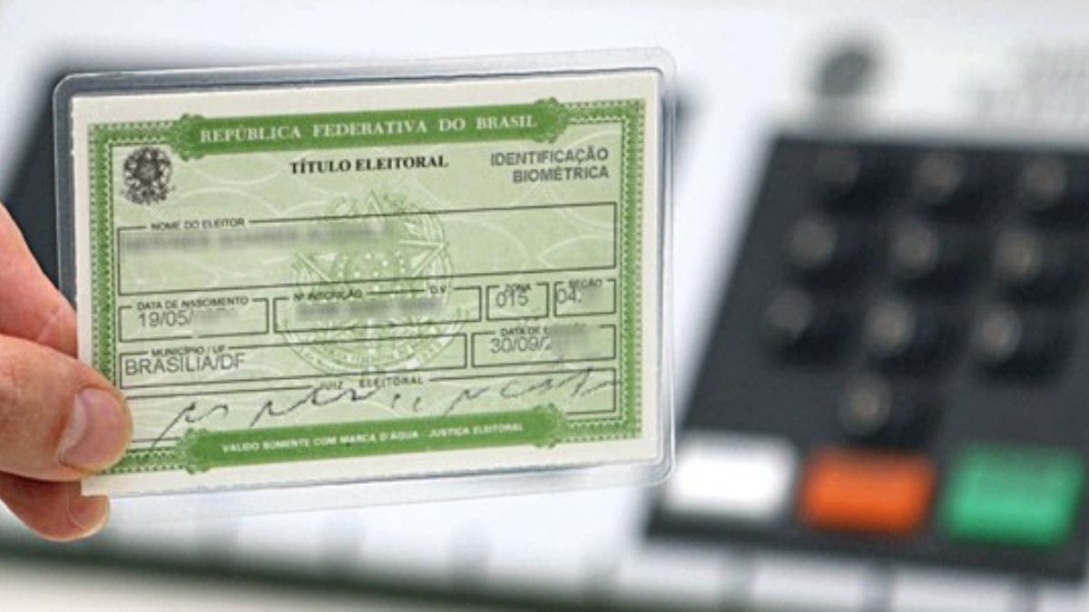 Titulo de eleitor em frente da urna eletrônica