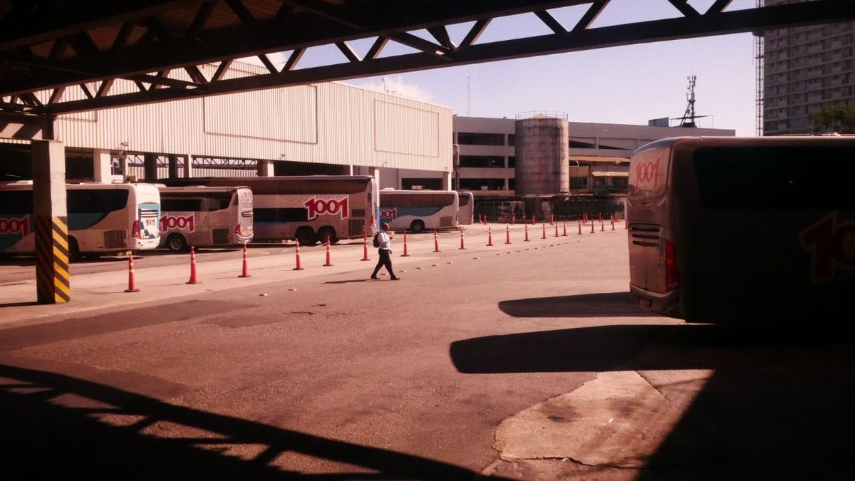 Patio de um terminal de ônibus ao entardecer, que permite o transporte interestadual