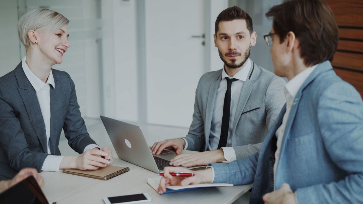 Executivos da empresa reunidos em uma sala para discutir liderança e gestão de tecnologia.
