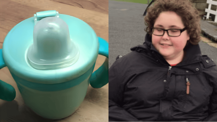 Copo infantil de plástico azul-claro com duas alças e bico de silicone, com sinais de desgaste na superfície.