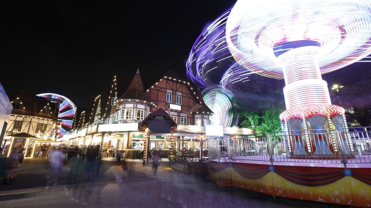 Oktoberfest Blumenau na Vila Germânica durante a noite, com brinquedos e arquitetura típica alemã