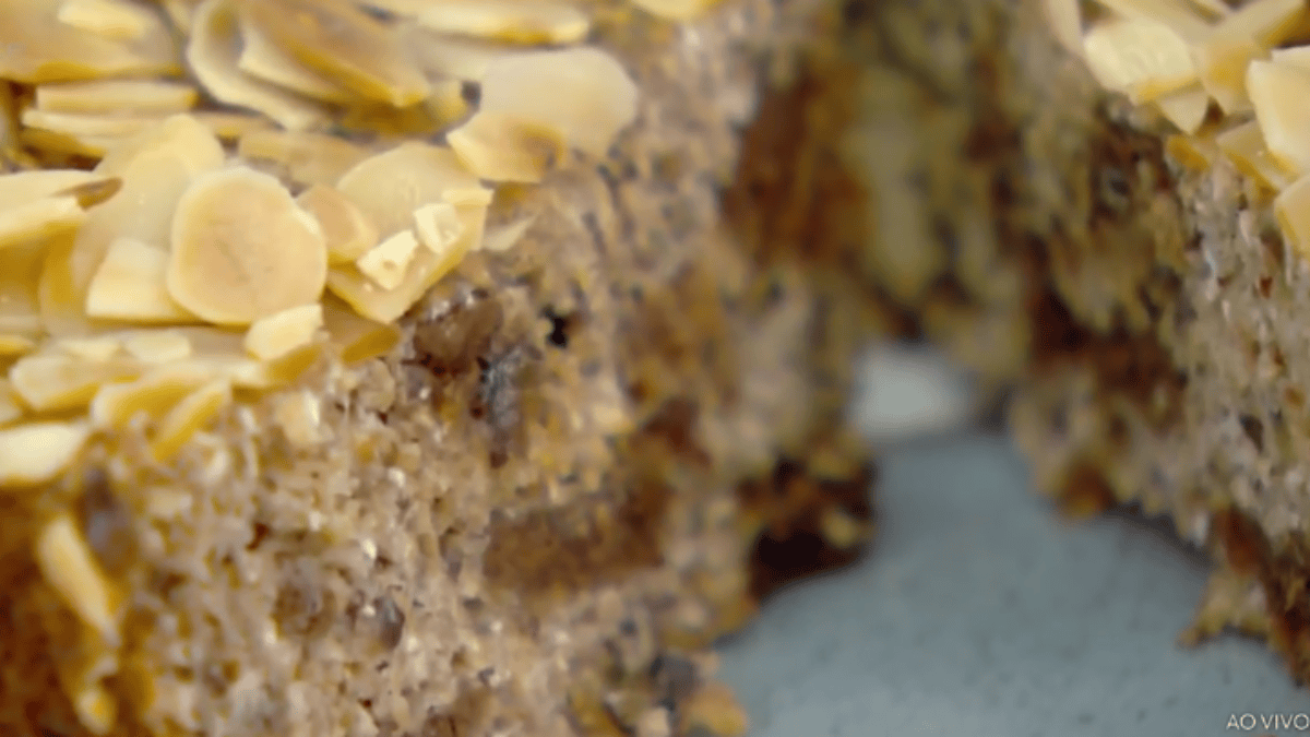 Bolo de banana sem glúten e sem açúcar cortado, mostrando a textura da massa e a cobertura de amêndoas.