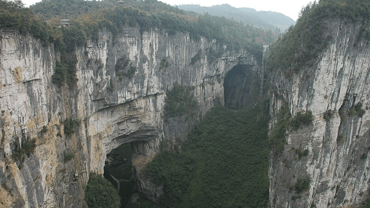 Enormes arcos naturais de pedra surgem entre desfiladeiros em Wulong, área de relevo cárstico onde a erosão abriu cavernas, dolinas e algumas das paisagens naturais mais monumentais de Chongqing (Foto: Brookqi / Wikimedia Commons)
