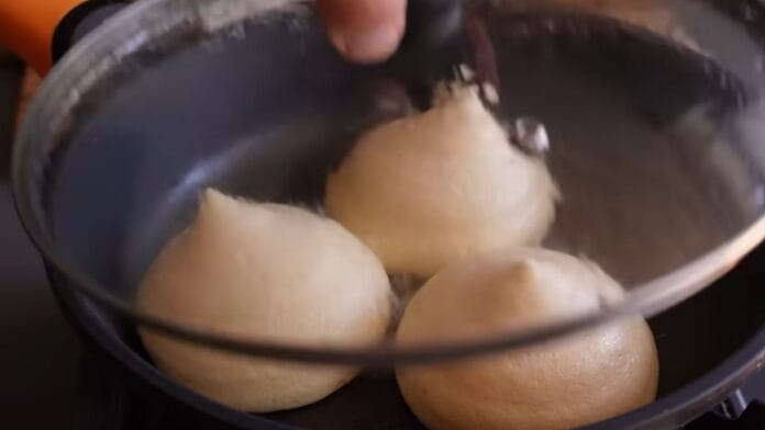 Frigideira com três panquecas sendo destampada