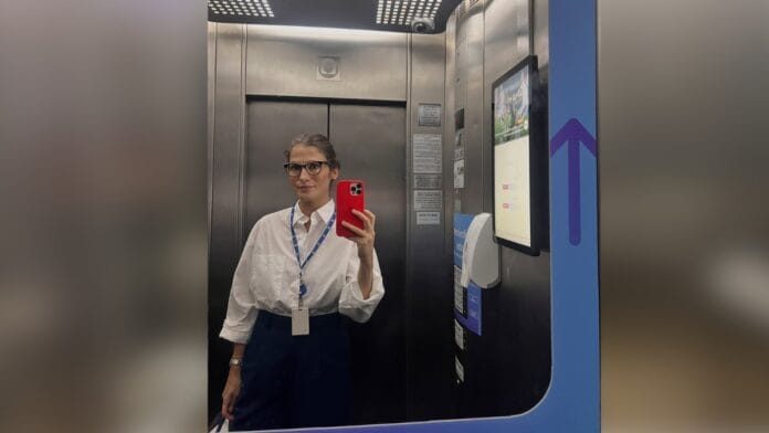 Jornalista Renata Vasconcellos, de cabelo castanho e óculos de armação escura, com camisa social branca e calça de alfaiataria preta