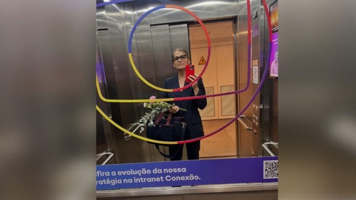 Jornalista Renata Vasconcellos, de cabelo castanho e óculos de armação escura, com blazer e calça de alfaiataria em preto