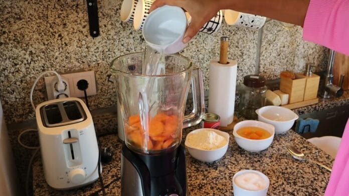 água sendo despejada no liquidificador junto com as cenouras
