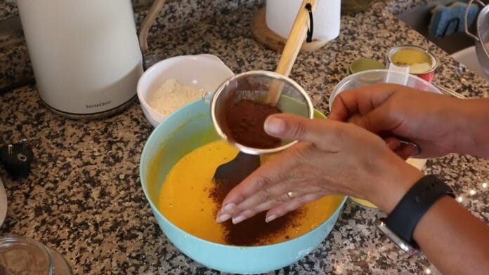 cacau em pó sendo adicionado em uma metade da massa