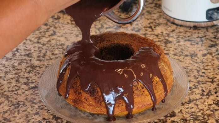 cobertura de chocolate sendo adicionada ao bolo já assado