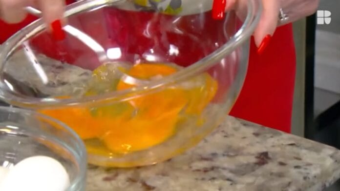 cozinheira batendo os ovos em uma vasilha