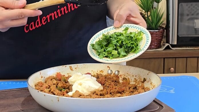 adicionando queijo e tempero a carne cozida
