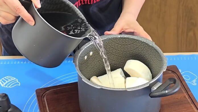 adicionando água na panela para o cozimento do aipim 