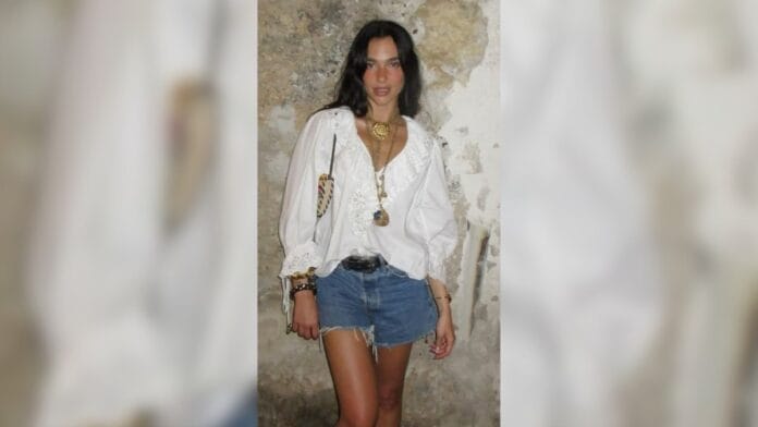 Mulher com bata branca e short jeans, cinto preto