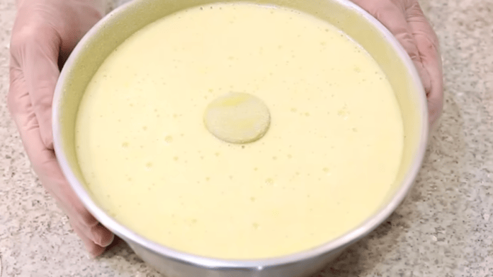 Massa amarela de bolo de milho dentro de uma forma redonda antes de assar.