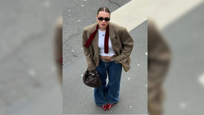 mulher com calça baggy, blusa branca e blazer largo