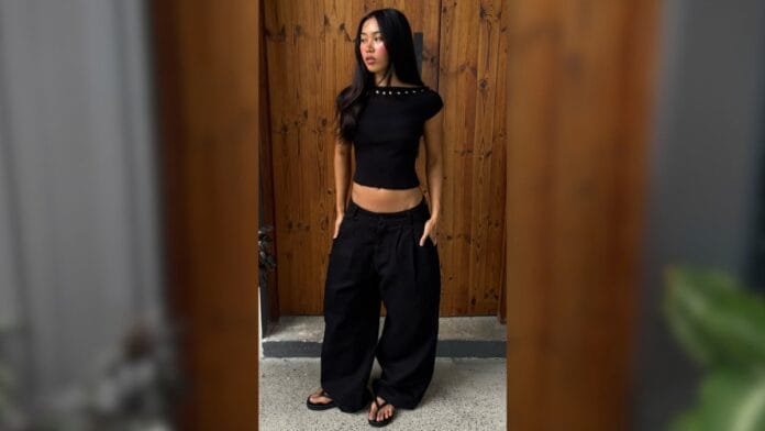 mulher com calça baggy preta e blusa babylook preta