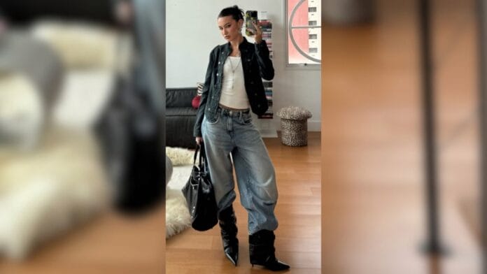 mulher com calça baggy, blusa branca, jaqueta preta e bolsa grande preta