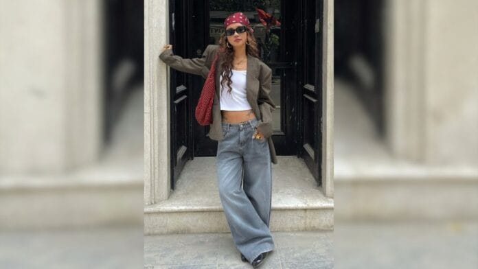 Mulher com calça baggy, cropped branco e blazer acinturado