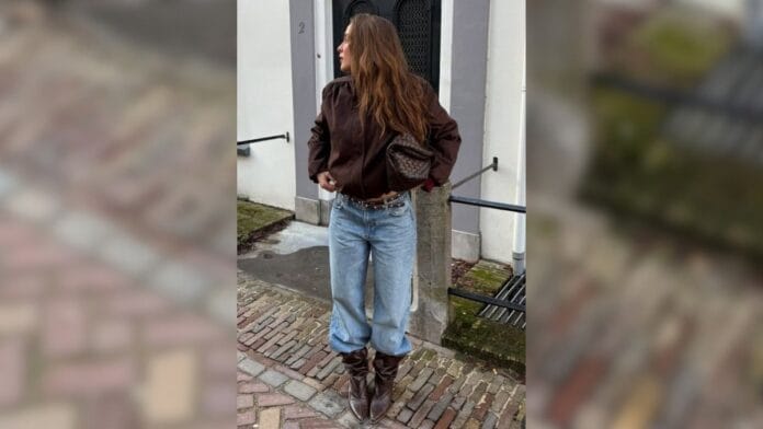 mulher com calça baggy, jaqueta de couro marrom e bota marrom