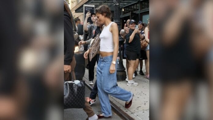 Mulher com regata branca e calça cintura baixa jeans clara