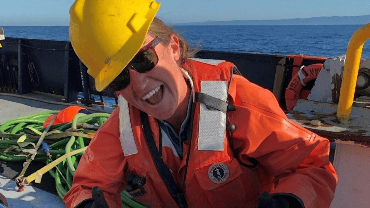 A geóloga Nora Nieminski posa com um testemunho sedimentar retirado da zona de subducção de Cascadia (Foto: Jenna Hill / USGS)