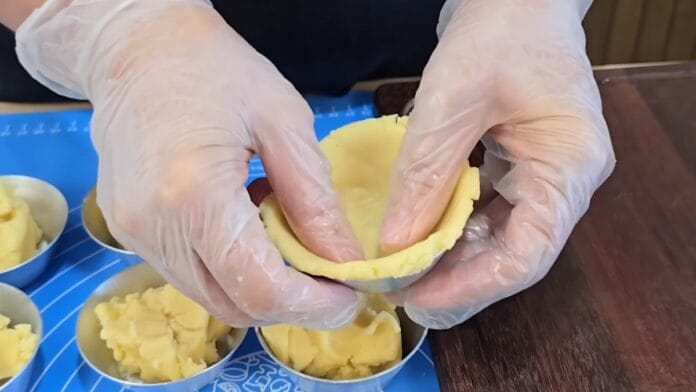 colocando a massa da empada na forma