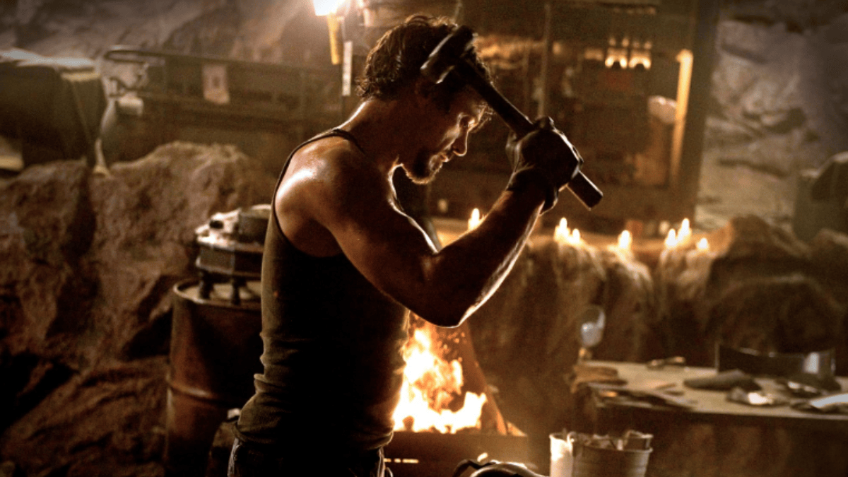 Essa cena parece ser uma alusão à clássica cena de Homem de Ferro, de 2008, em que Tony Stark forja as peças do que viria a ser sua primeira armadura: Mark I (Foto: Divulgação / IMDb)
